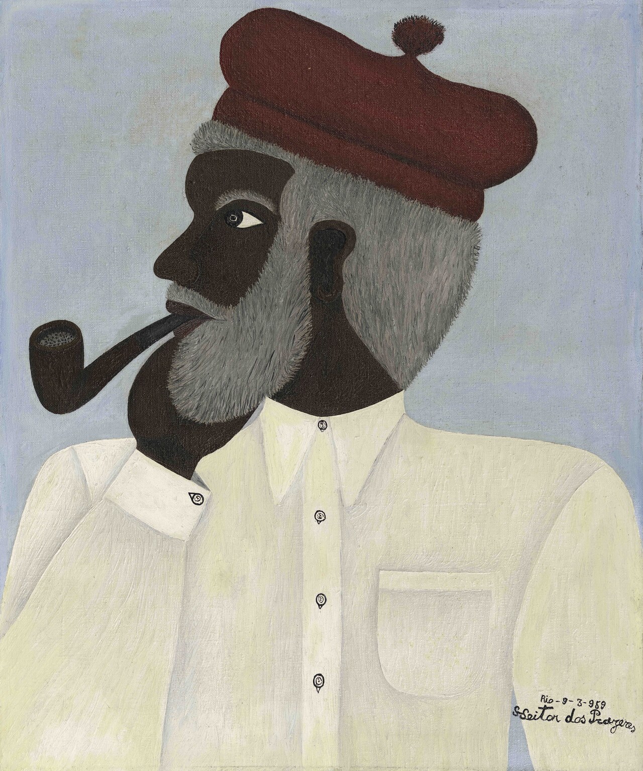 Homem negro de perfil voltado à esquerda, com barba e cabelos grisalhos, boina vermelha e camisa clara, fuma cachimbo contra um fundo azul.